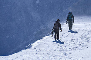 two snowboarders on the way to the next run