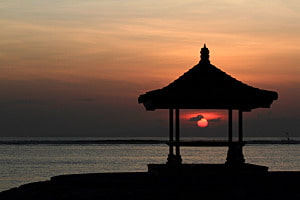 Sonne im Pavillon - Sonnenaufgang am Strand von Sanur auf Bali, Indonesien