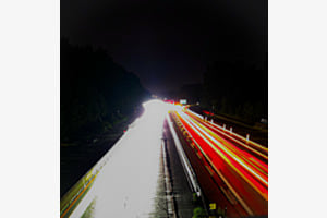 Die Autobahn leuchtet die Nacht auf