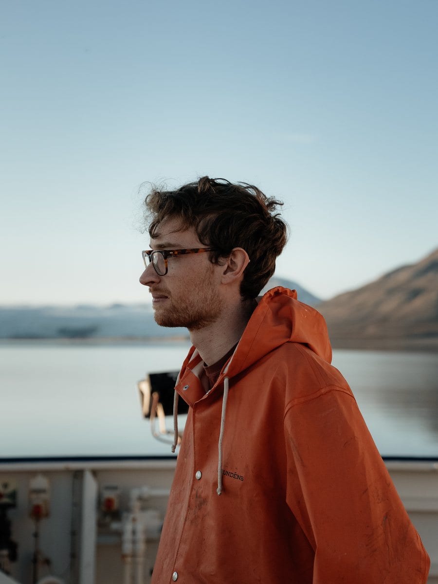 Forscher an Deck vor einem Fjord